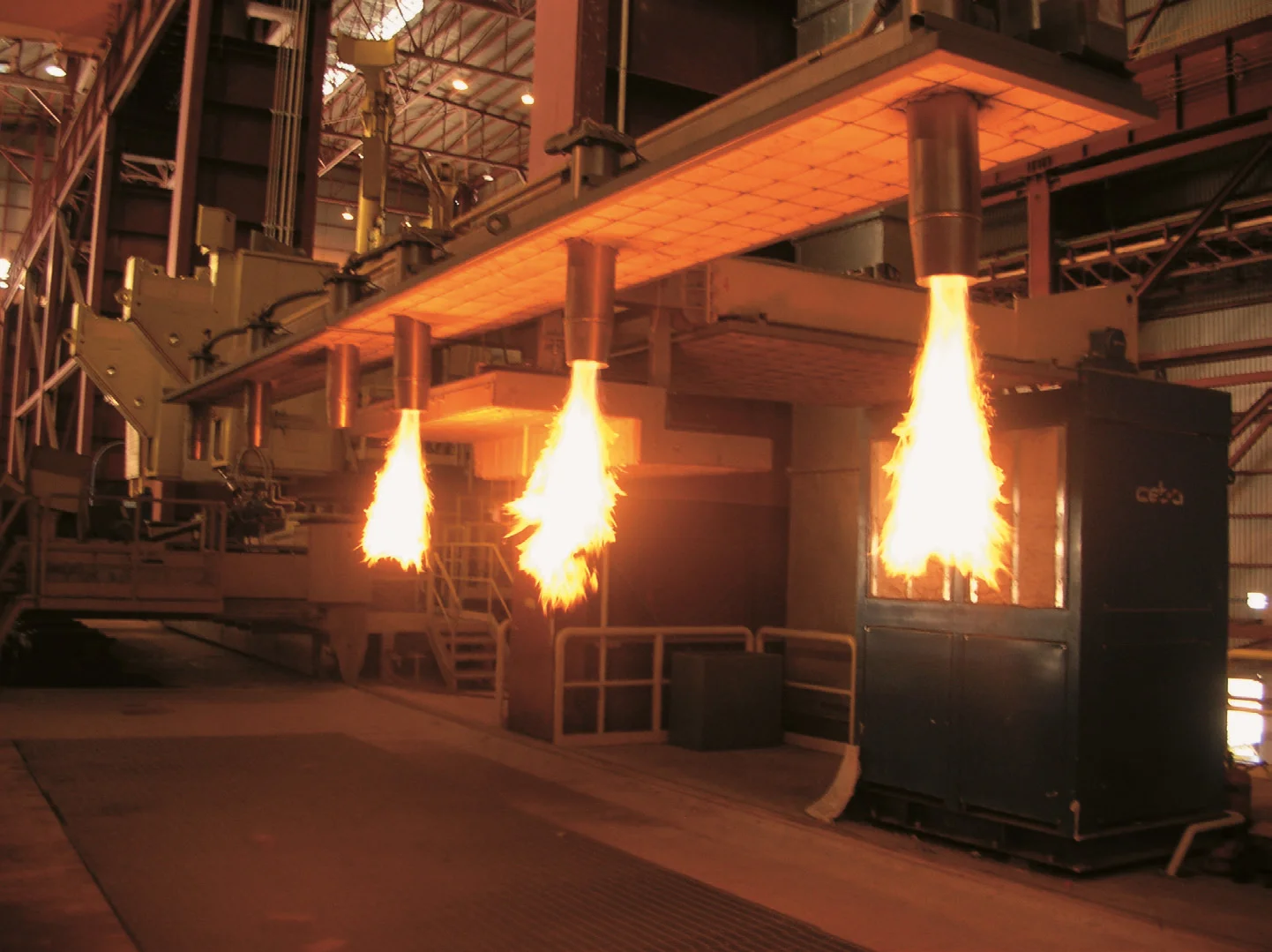 High-performance gas burners in operation inside an industrial reheating furnace at a steel manufacturing plant