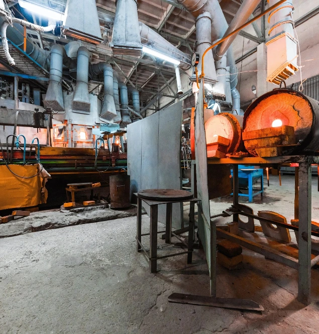 Forging furnace heating steel billet at high temperature in an industrial metalworking facility